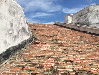 Low angle view of brick wall against sky