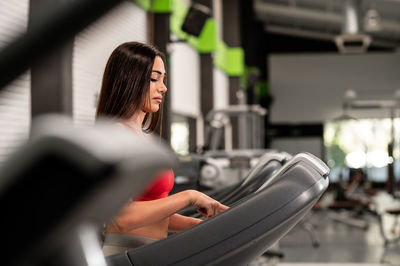 A pretty caucasian woman using a treadmill at the gym