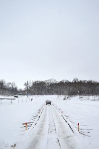 Snow covered landscape against clear sky