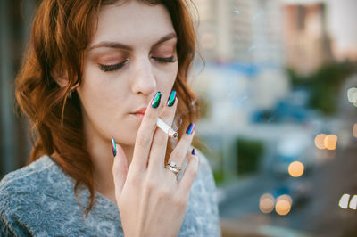 Close-up of woman smoking cigarette in city