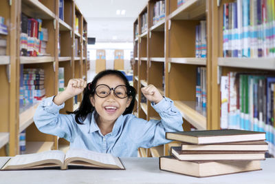 Smiling girl with books in library