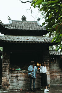 People standing outside temple against building