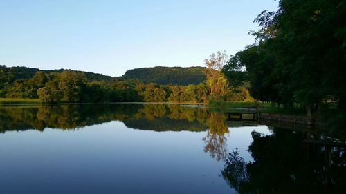 Reflection of trees in lake against clear sky