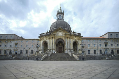 Facade of building against cloudy sky