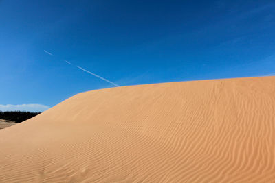 Scenic view of desert against clear blue sky