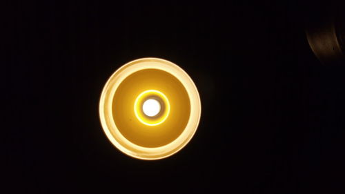 Close-up of illuminated candle against black background