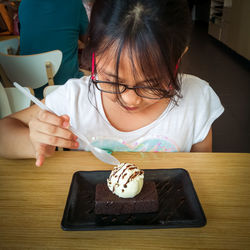 Girl eating ice cream at table