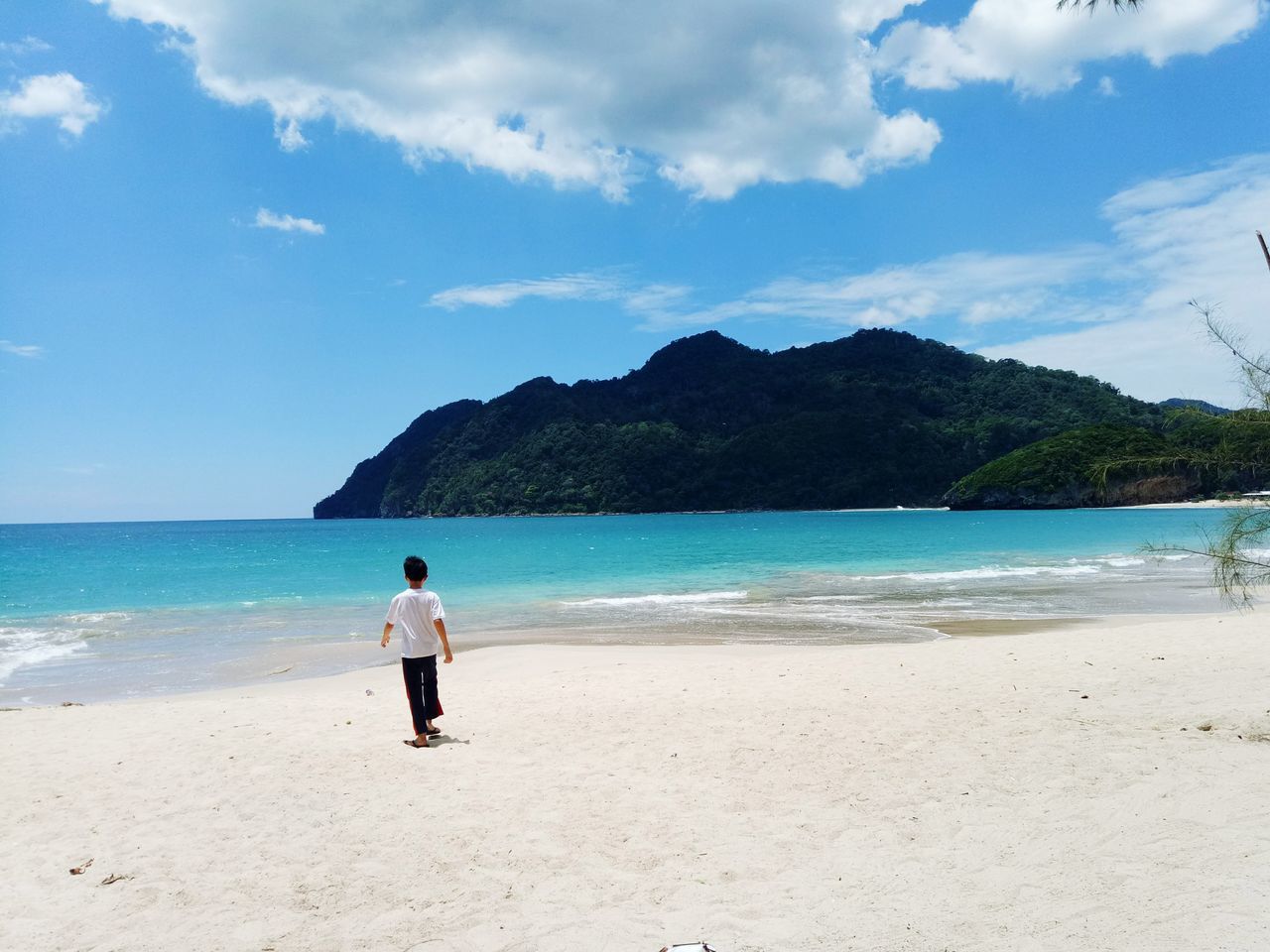 WOMAN ON BEACH AGAINST SKY