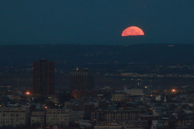 Illuminated cityscape against sky at night