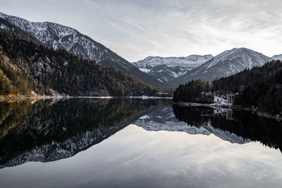 Mountains and building reflecting in a calm mirror lake