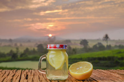 Drink on table against sky during sunset