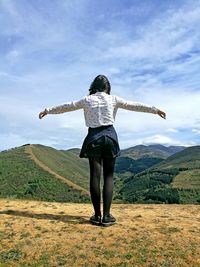 Full length rear view of woman standing on mountain