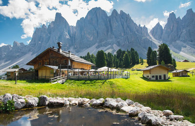 Houses by mountain against sky