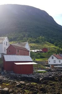 Houses by buildings against sky