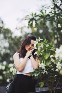 Portrait of beautiful woman standing by plants