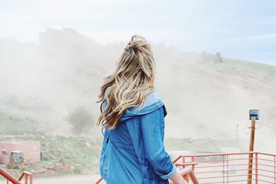 Rear view of woman standing against mountain