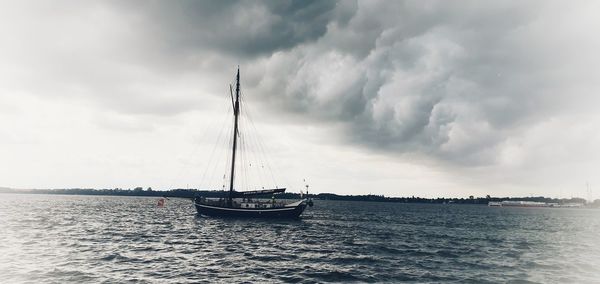 Sailboat sailing on sea against sky