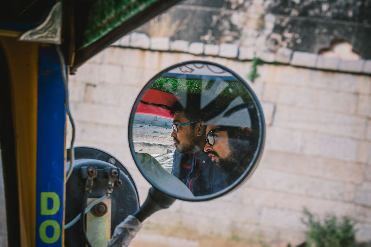 reflection, side-view mirror, real people, day, window, one person, land vehicle, close-up, outdoors, photographing, tree, camera - photographic equipment, technology, people