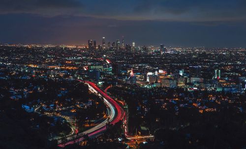 Aerial view of illuminated cityscape against sky at night