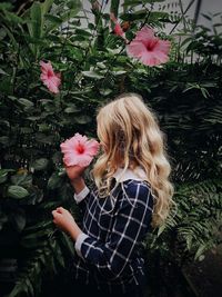 Girl holding pink hibiscus flower