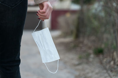Midsection of woman holding umbrella standing on paper
