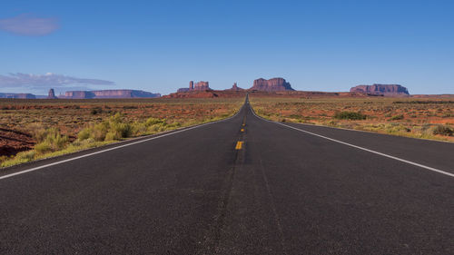 Road leading towards mountain against sky