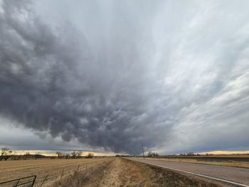 Road amidst field against sky