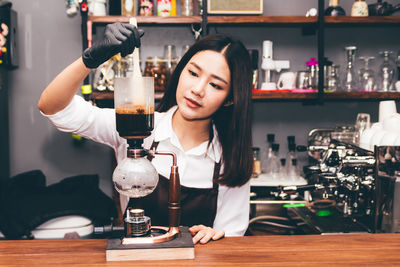 Portrait of woman holding drink in restaurant