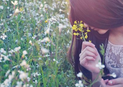 Close-up of woman holding flower blooming outdoors