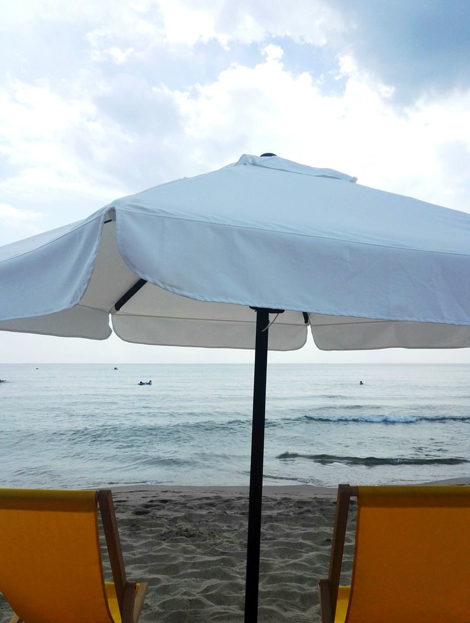 DECK CHAIRS ON BEACH AGAINST SKY