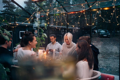 Happy young friends having dinner party in cabin