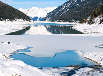 Scenic view of frozen lake and snowcapped mountains