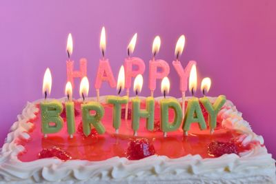 Close-up of birthday cake against pink background