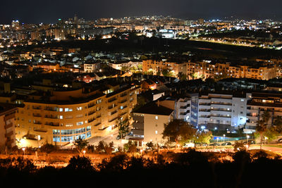 High angle view of illuminated cityscape against sky at night