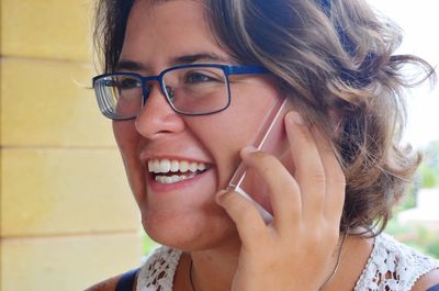 Close-up of smiling woman talking on mobile phone