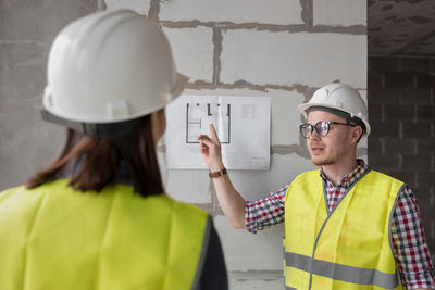 Man wearing hat explaining plan to colleague