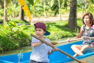 Full length of mother and son kayaking over river