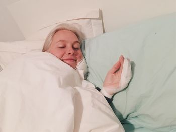 High angle view of young woman sleeping on bed at hospital