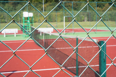 Full frame shot of tennis court seen through chainlink fence