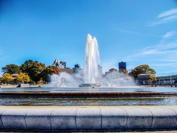 Fountain in city against sky