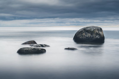 Rocks in sea against sky