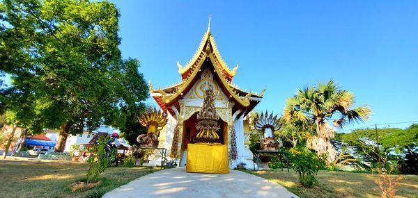 Temple against trees and building against sky