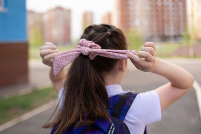 Back to school. girl in school uniform with parent go to school with backpack behind their backs. 