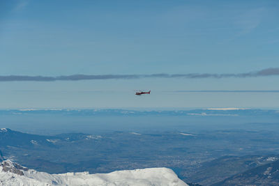 Jungfraujoch, canton bern, switzerland, february 11, 2023 helicopter is flying along the mountains