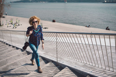 Full length of woman climbing steps in city