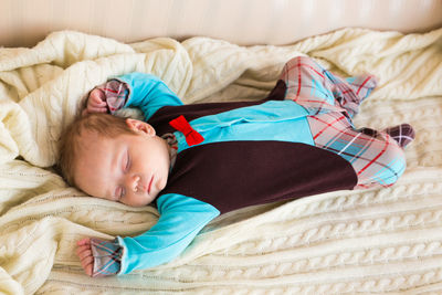 High angle view of cute boy sleeping on bed