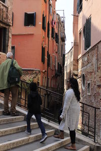 Rear view of people walking on street amidst buildings