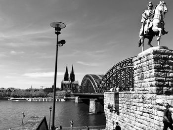 Bridge over river against buildings in city