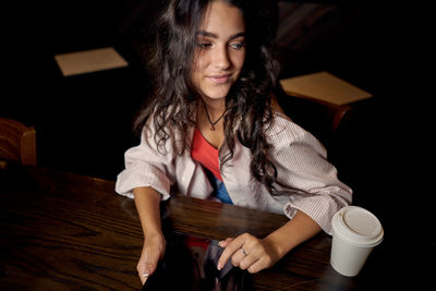 Portrait of young woman sitting on table