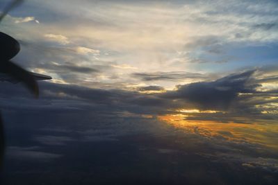 Close-up of airplane wing against sky during sunset